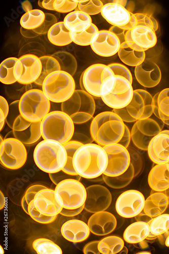 Decorative golden color bubbles bokeh on a black background. Lights for christmas