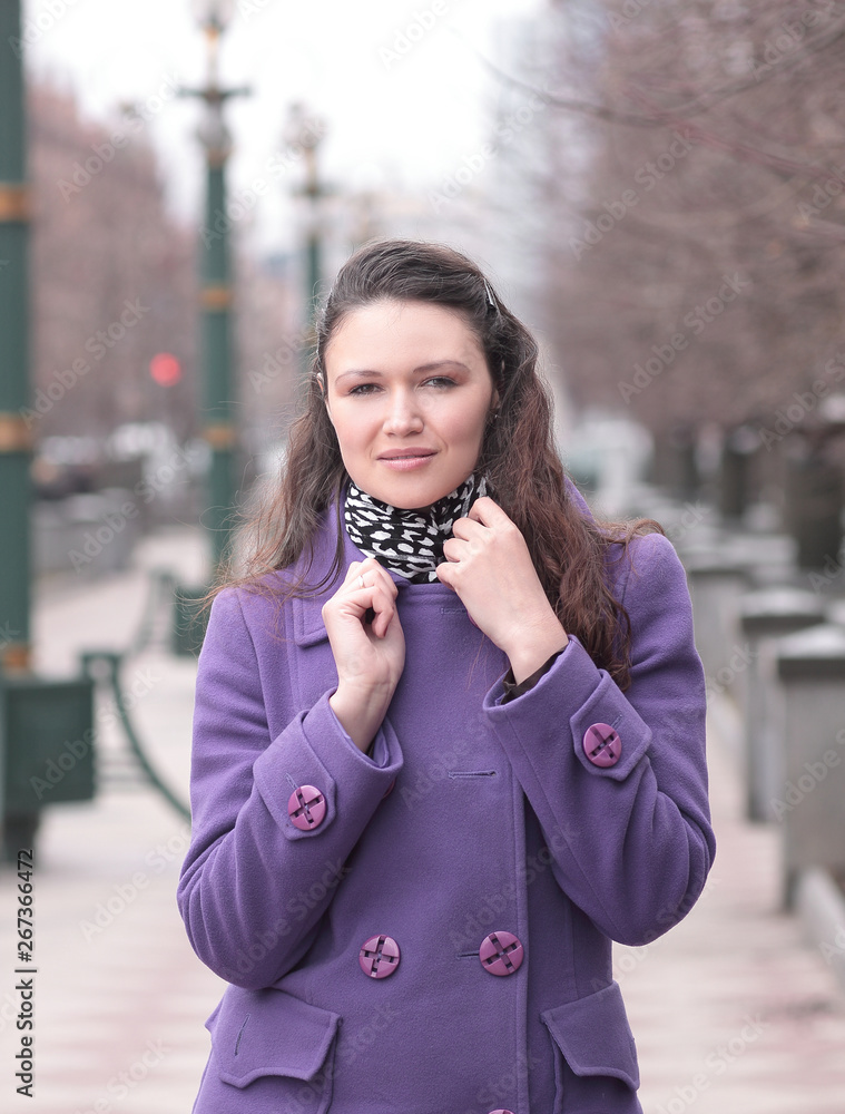 beautiful woman in casual clothes standing on city street on autumn day.