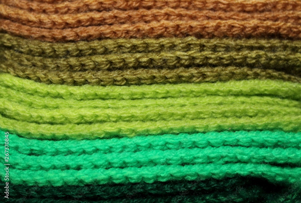 Colorful green design background of knitted woolen elements in a pale