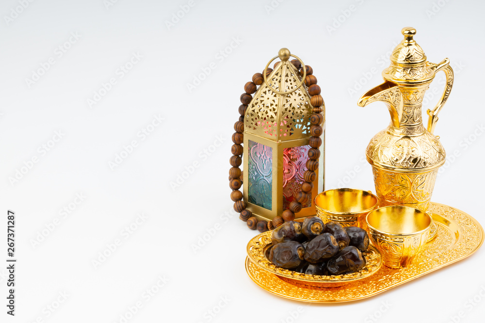 Fototapeta premium Premium dates, lantern and arabic coffee mug on white background. Selective focus, copy space and Ramadan Kareem concept