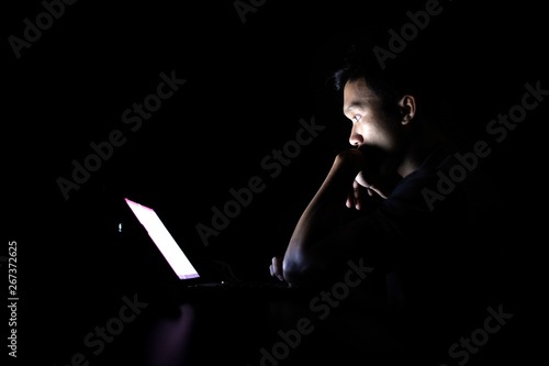 Lonely developer thinking solution with laptop at night in the dark room