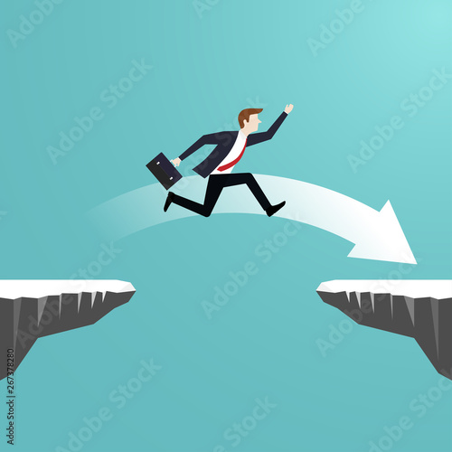 Businessman jumping over chasm of cliff go to the success