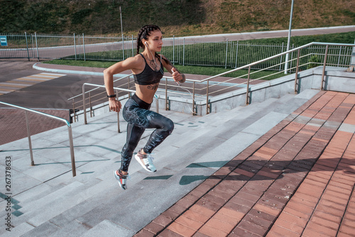 Girl athlete woman, runs stairs, summer city, free space, fitness workout, day morning. Sportswear top sneakers. Active lifestyle, motivation power. Endurance achievement success, muscles competitions