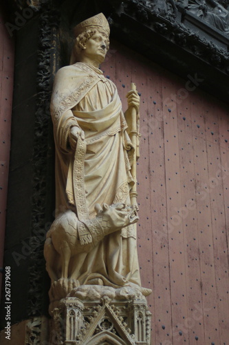 Rouen, France : In the courtyard of The Rouen Cathedral. The stone statue of St. Romain (Archbishop of Rouen) with a terrible dog by his foot
