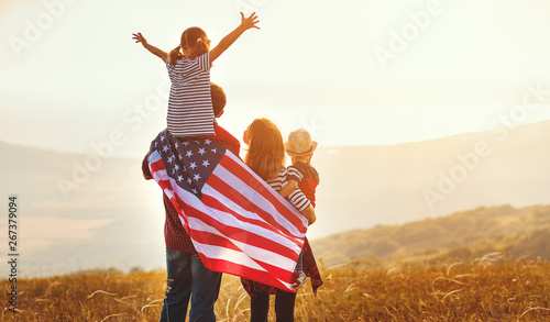 happy family with flag of america USA at sunset outdoors. photo