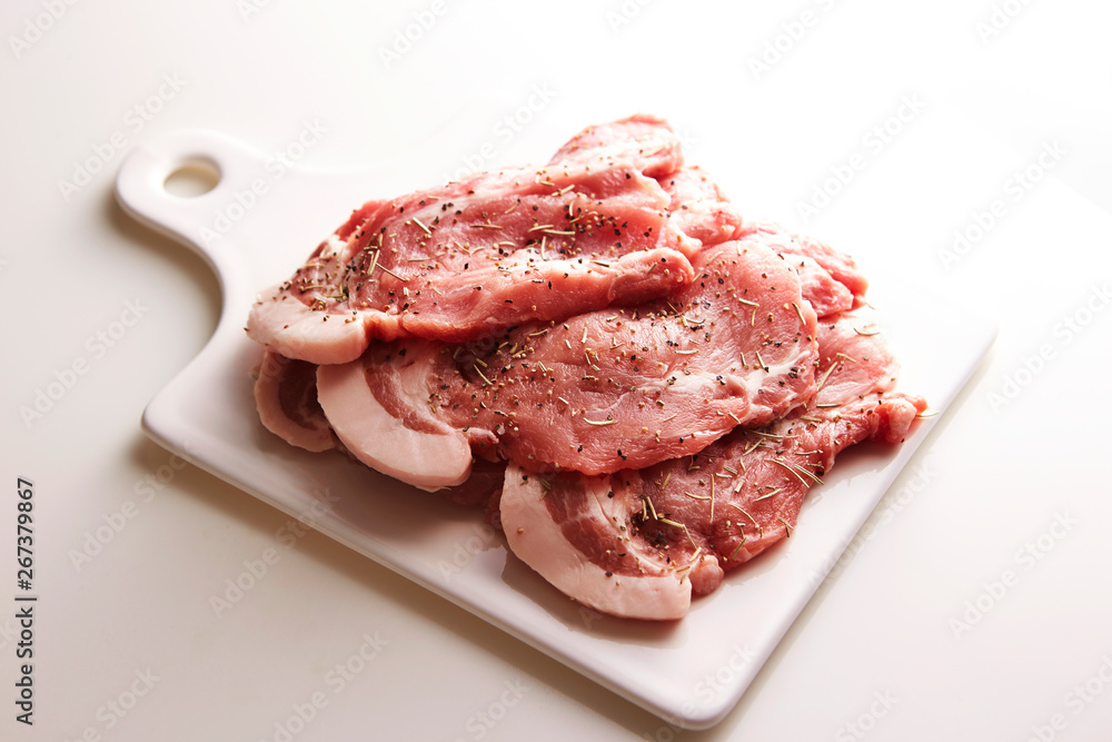 Fresh raw seasoned pork on cutting board Fresh raw seasoned pork on cutting board