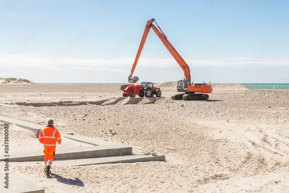Fototapeta premium Excavator on the beach in Norre Vorupor, Denmark.