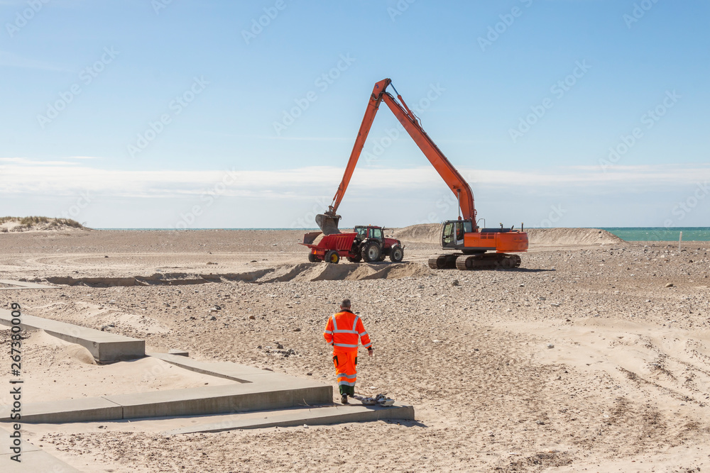 Excavator on the beach in Norre Vorupor, Denmark.