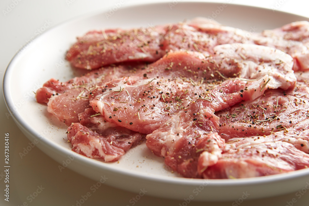 Fresh raw seasoned pork on plate 