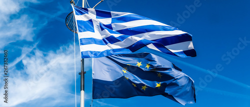 Flags of Greece and European Union on blue sky background, politics of Europe photo