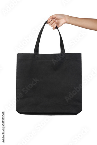 Hand holding blank black fabric canvas bag isolated on white background with clipping path, eco concept.