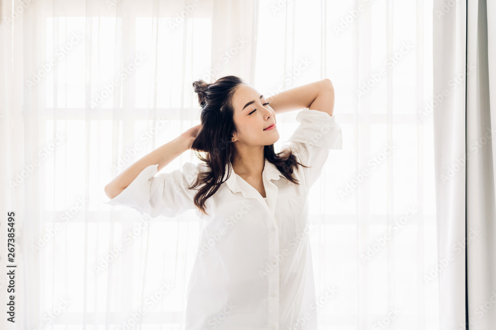 Woman stretching happy and relaxed after wake up in the morning at home Woman stretching happy and relaxed after wake up in the morning at home