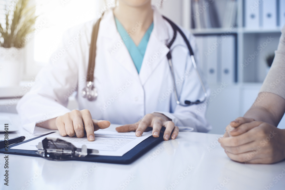 Doctor and patient are discussing something in clinic, just hands at the desk. Medicine and best service concept Doctor and patient are discussing something in clinic, just hands at the desk. Medicine and best service concept