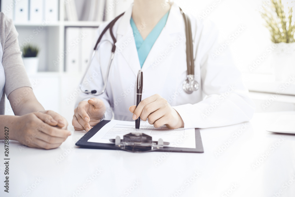 Doctor and patient are discussing something in clinic, just hands at the desk. Medicine and best service concept Doctor and patient are discussing something in clinic, just hands at the desk. Medicine and best service concept