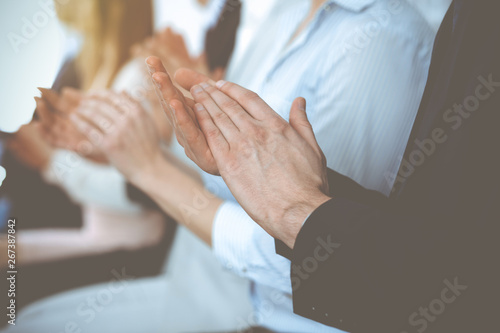 Business people clapping and applause at meeting or conference  close-up of hands. Group of unknown businessmen and women in modern white office. Success teamwork or corporate coaching concept