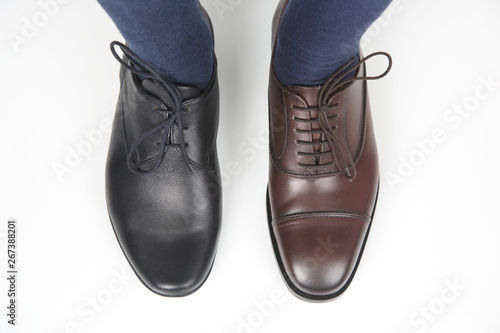 man's feet in classic brown and black shoes