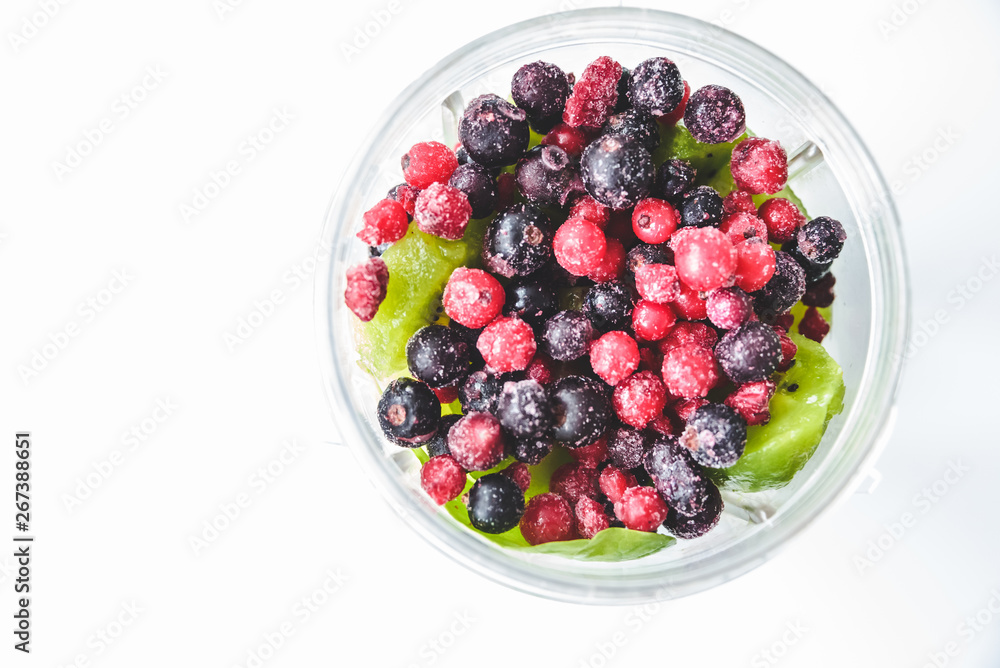 Flat lay of a blender and fresh seasonal berries and fruits over white background, preparing smoothies, detox, healthy clean eating. Summer drinks. Flat lay of a blender and fresh seasonal berries and fruits over white background, preparing smoothies, detox, healthy clean eating. Summer drinks.