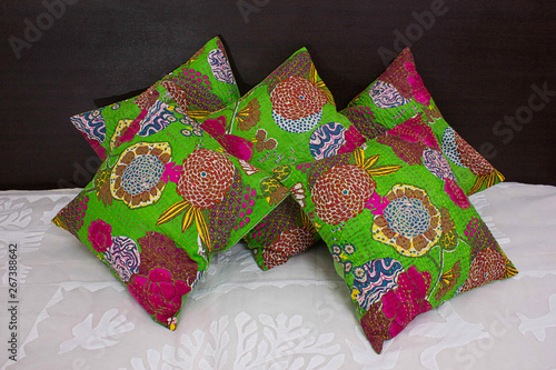 Parrot green floral ethnic cushions on bed photo