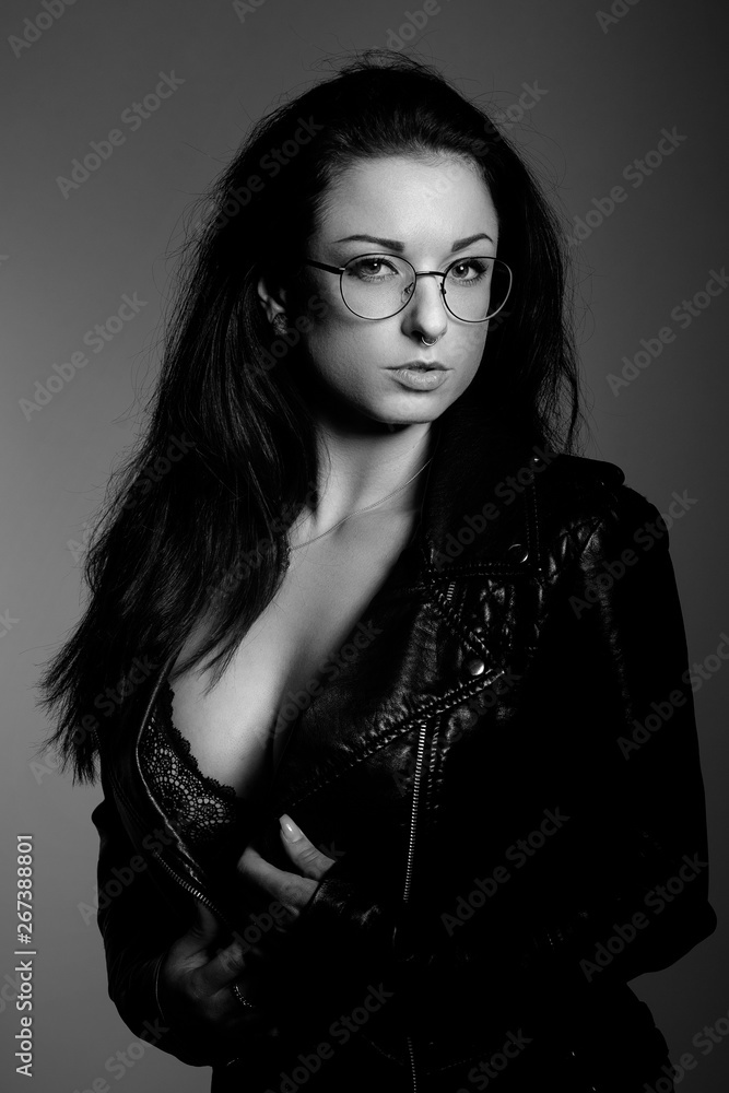 Wunderschönes schwarzhaariges Model in schwarzweiß im Studio mit Brille, Pullover und Stiefel Wunderschönes schwarzhaariges Model in schwarzweiß im Studio mit Brille, Pullover und Stiefel