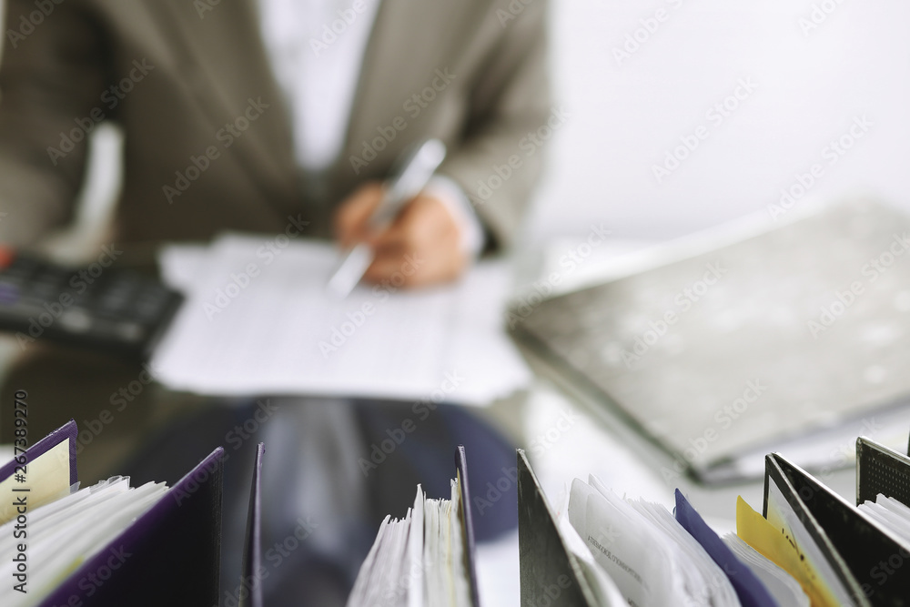 Bookkeeper woman or financial inspector making report, calculating or checking balance, close-up. Business, audit or tax concepts Bookkeeper woman or financial inspector making report, calculating or checking balance, close-up. Business, audit or tax concepts