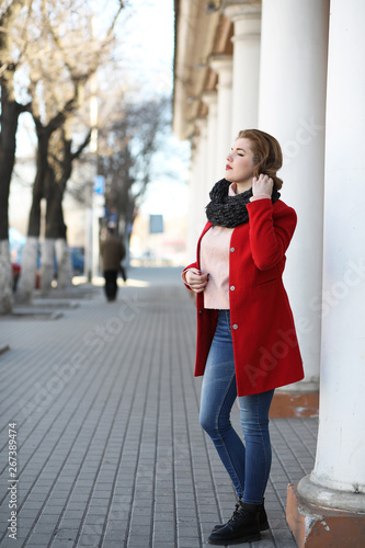 Pretty girl on a walk in red coat in the city © alexkich