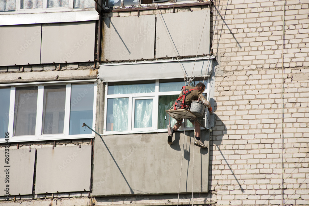 Warming of wall in a high-rise building. High-altitude work.