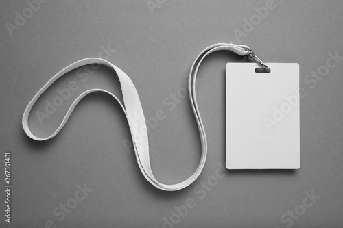 Empty layout layout on grey background. Common blank label name tag hanging on neck with thread. photo