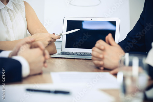 Group of businesspeople or lawyers discussing contract papers and financial figures while sitting at the table. Close-up of human hands at meeting or negotiations. Success and communication concept