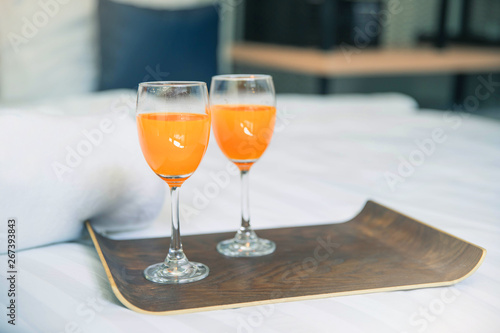 Bed breakfast with orange juice on white sheets. Healthy breakfast with orange juice in wooden tray. bed breakfast.