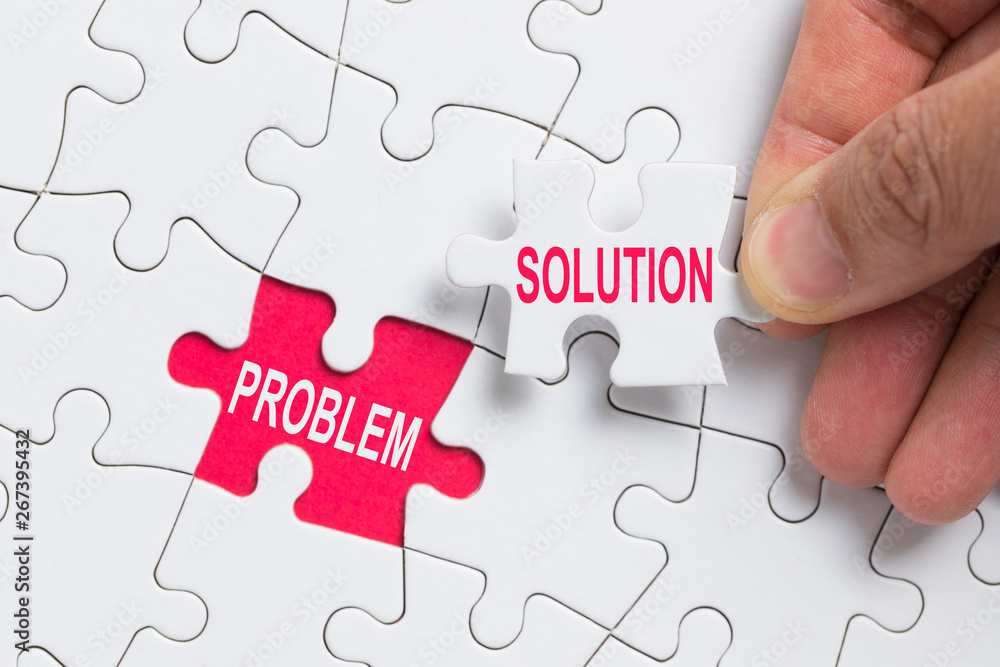 Hand holding piece of white jigsaw puzzle with word problem and solution. Hand holding piece of white jigsaw puzzle with word problem and solution.