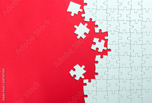 Red background made from white jigsaw puzzle pieces and place for your content