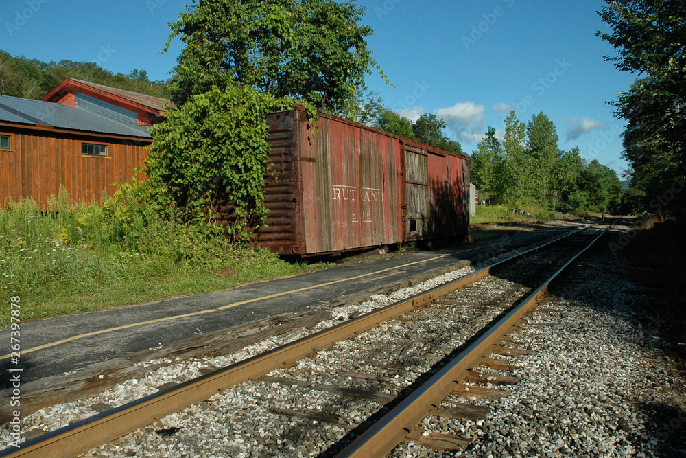 Abandoned railway boxcar on siding, rail tracks and trees Abandoned railway boxcar on siding, rail tracks and trees
