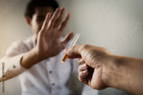 Fotografie World No Tobacco Day in May, stop smoking concept, young man give cigarette but