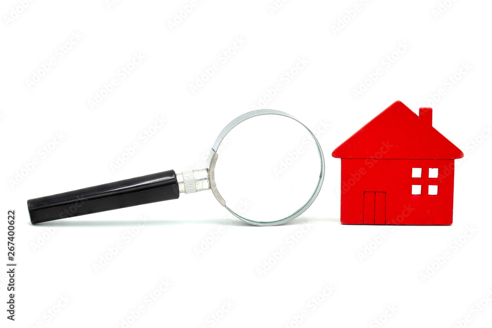 Red wooden houses and magnifying glass on a white isolated background. Home search concept. Real estate concept. Real estate appraisal. property Red wooden houses and magnifying glass on a white isolated background. Home search concept. Real estate concept. Real estate appraisal. property