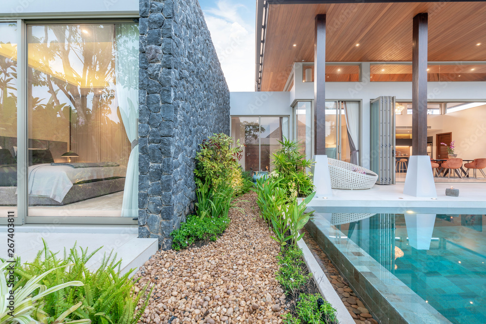 © Stock PK - home or house Exterior design showing tropical pool villa with greenery garden and bedroom