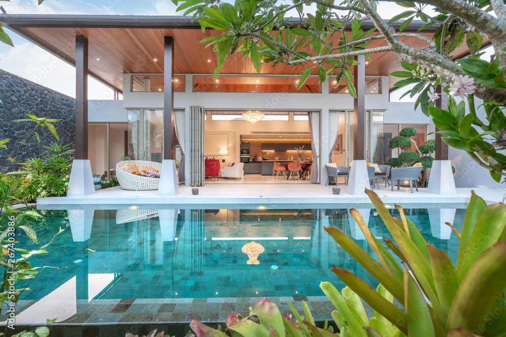 © Stock PK - home or house building Exterior and interior design showing tropical pool villa with green garden