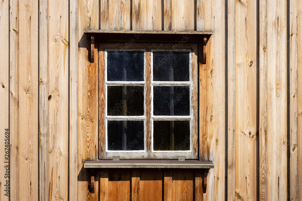 The old window of old wooden house. Background of wooden walls The old window of old wooden house. Background of wooden walls