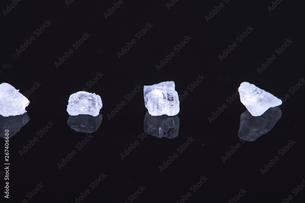 single coarse salt crystals on a black background for health purposes single coarse salt crystals on a black background for health purposes