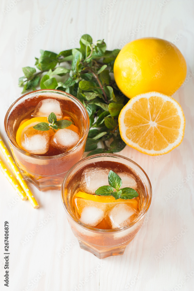 Refreshing citrus lemonade, summer drink. Ice tea with fresh lemon and mint on wooden background. Refreshment beverage concept. Refreshing citrus lemonade, summer drink. Ice tea with fresh lemon and mint on wooden background. Refreshment beverage concept.