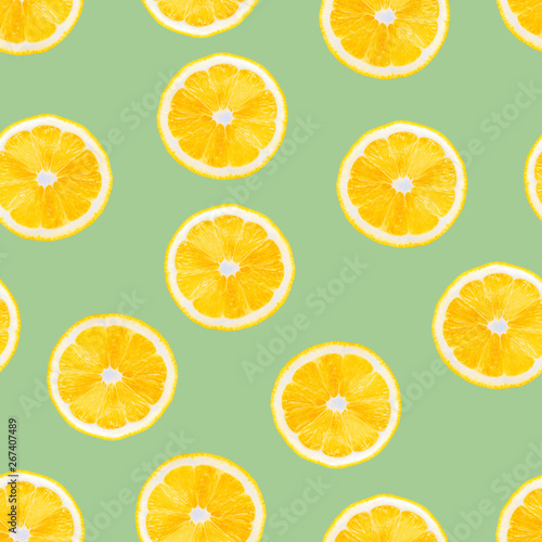 Summer seamless pattern with lemons slice on pastel green background. Lemon texture design for textiles, wallpaper, fabric.