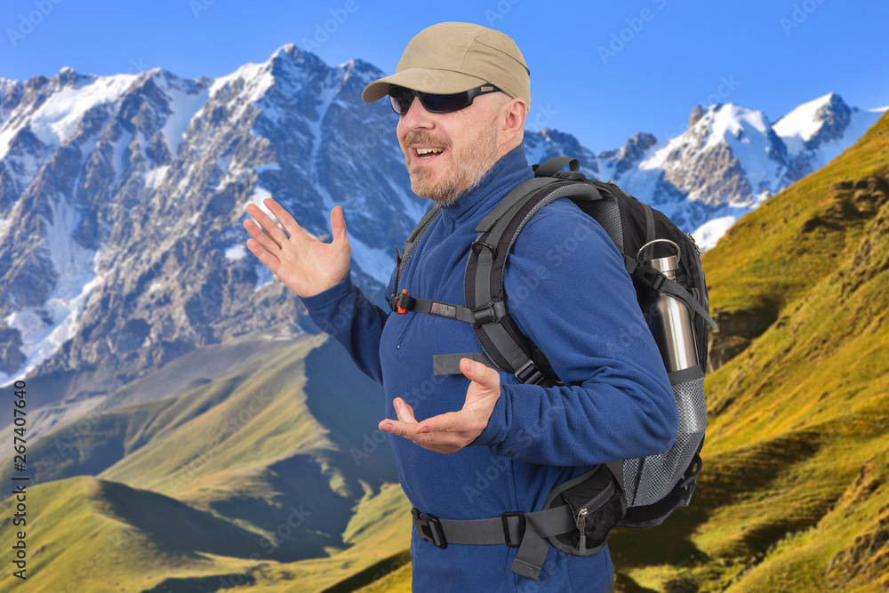 Happy male tourist with backpack is traveling in the highlands