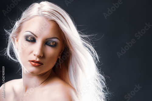 Attractive young blonde woman with bright makeup posing