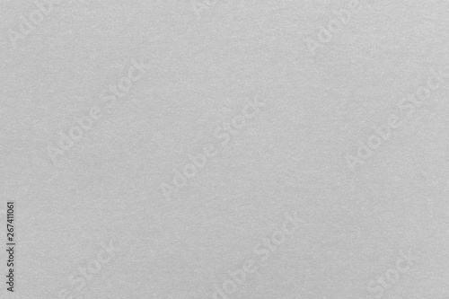 Abstract grey glossy paper texture background or backdrop. Empty gray cardboard or shiny paperboard for decorative design element. Simple grainy textured surface for journal template presentation