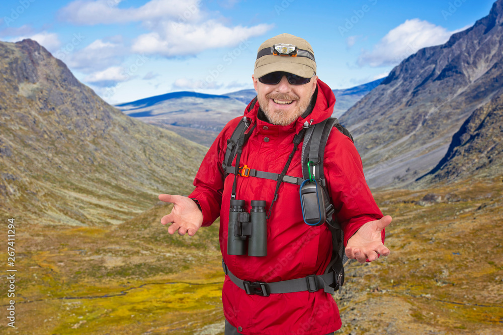 Happy man tourist with backpack is traveling in the highlands