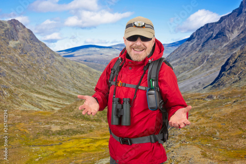 Happy man tourist with backpack is traveling in the highlands