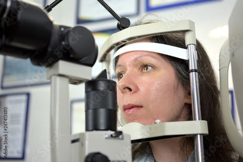 pretty young woman undergone an ocular fundus inspection with ophthalmologist, low depth of field
