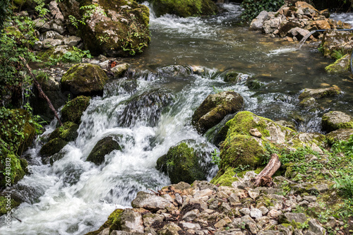 Beautiful view of natural waterfall with crystal clear water among green woods