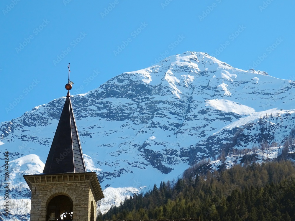 View of a church in the Italian Alps on a sunny day in the village of Macugnaga, Italy - April 2019