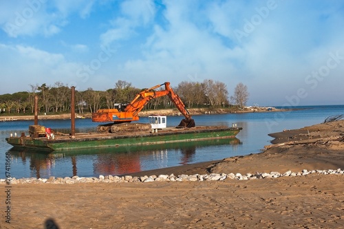 Excavator for channel dredge on a barge.