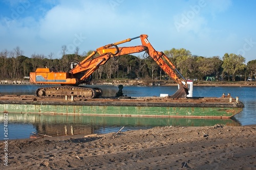 Excavator for channel dredge on a barge.